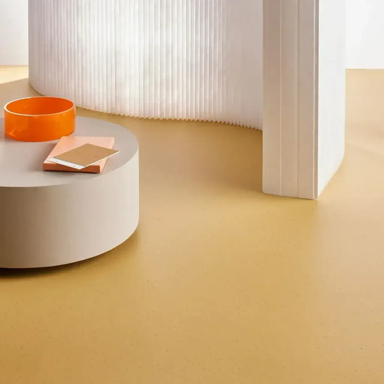 Piso color ocre en un espacio con mobiliario redondo